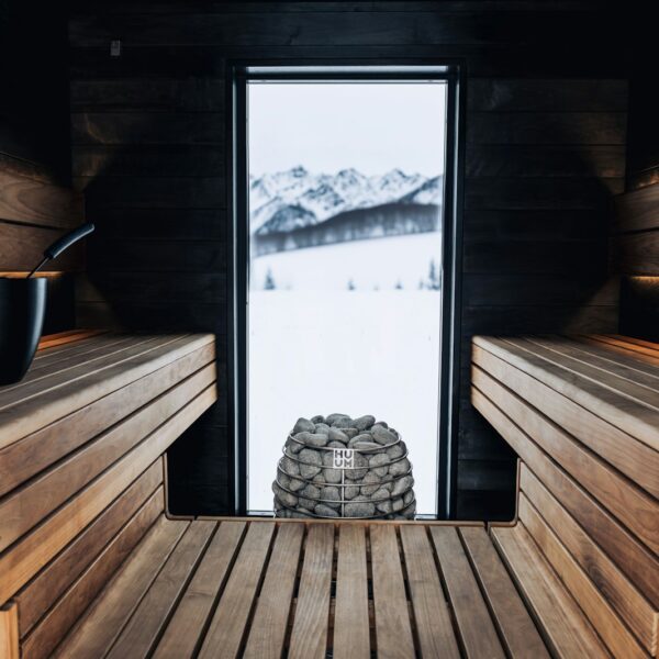 a wooden sauna with a window and a stack of rocks