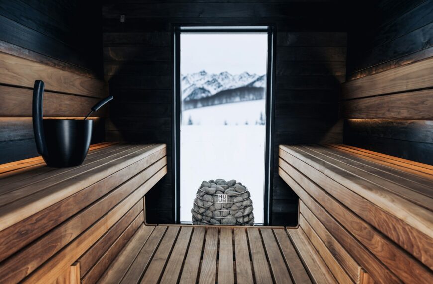 a wooden sauna with a window and a stack of rocks