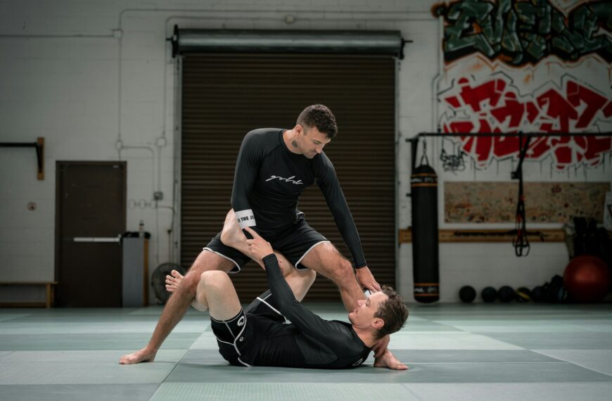 a couple of men standing on top of each other in a gym