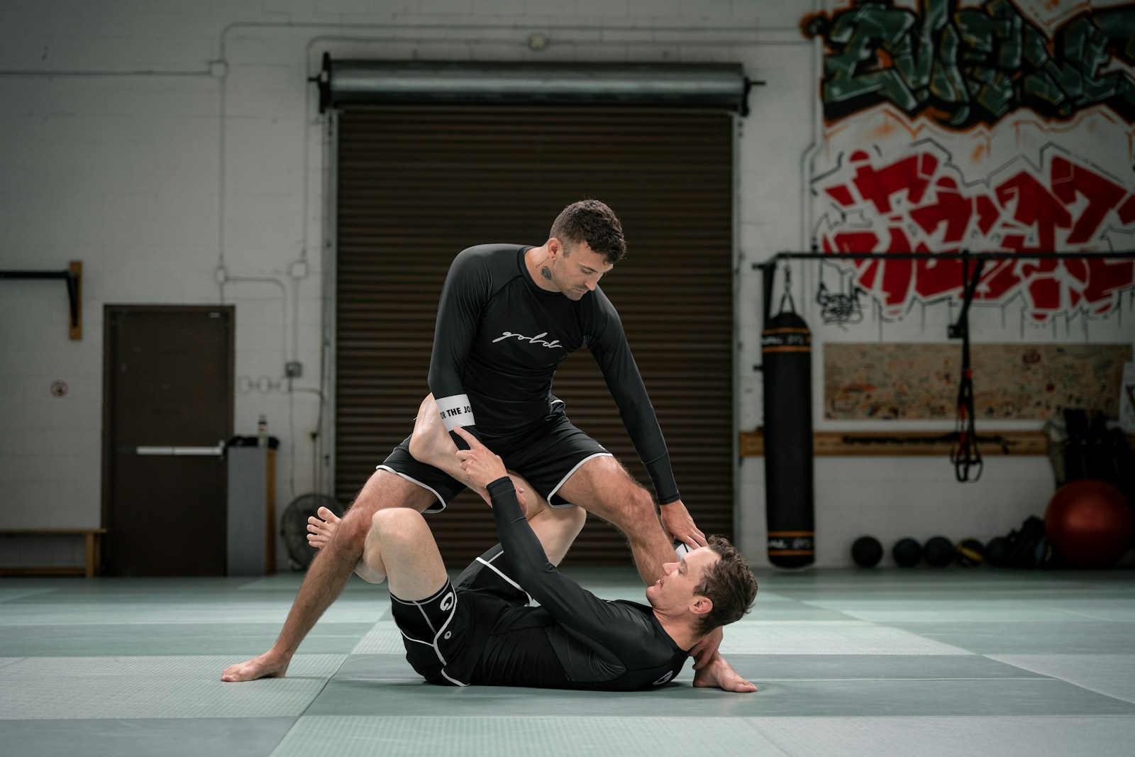 a couple of men standing on top of each other in a gym